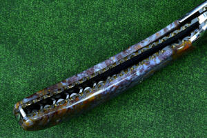 Macro enlargement of "Starling" fine handmade custom folding knife, lock view,  liner and blade filework detail. Note differentially anodized blue and gold titanium liners and full fine filework throughout