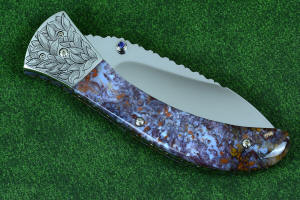 Macro enlargement of "Starling" fine handmade custom folding knife, reverse side view in high molybdenum stainless steel blade, engraved stainless bolsters, faceted amethyst gemstone accents and Rio Grande Agate handle