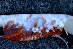 "Temno" obverse side gemstone handle 6X enlargement, note billowing flames of carmine colored agate and white fossil forms in this hard and striking gemstone